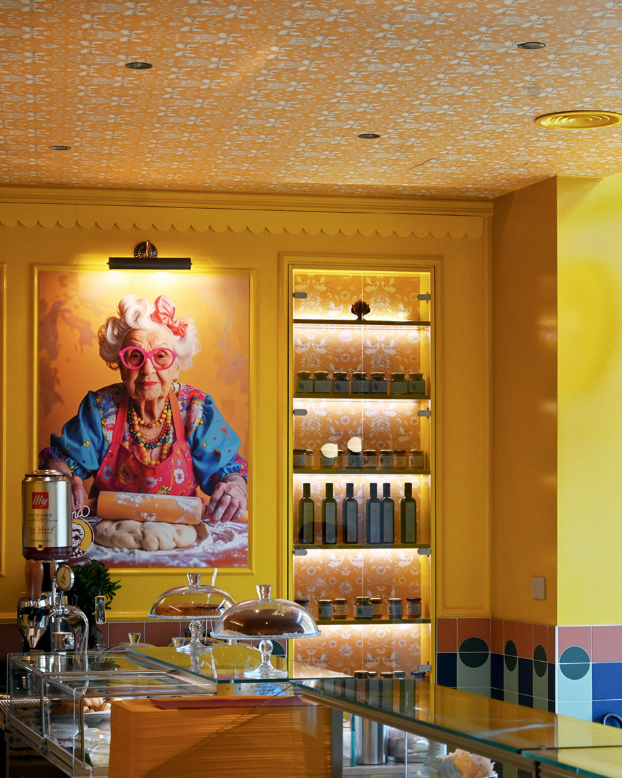 Counter area of Da Nonna restaurant with ceramic surfaces, display case and large scenographic portrait