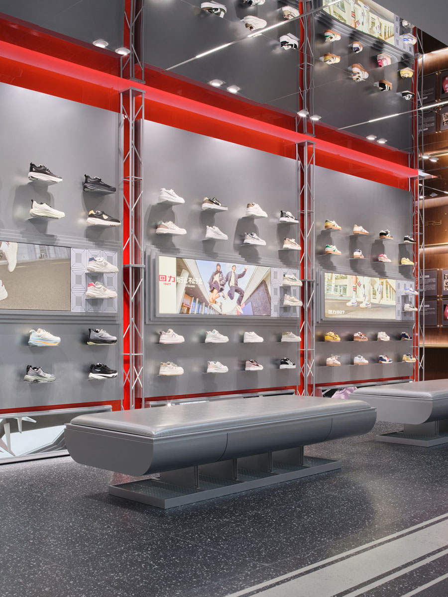 Central sculptural installation with metallic elements and red lighting inside the Warrior 1927 flagship store