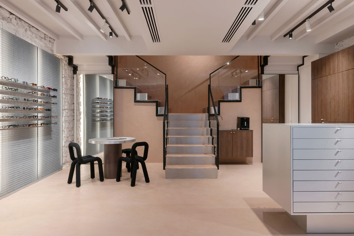 Consultation area with round table, black design chairs and eyewear display walls