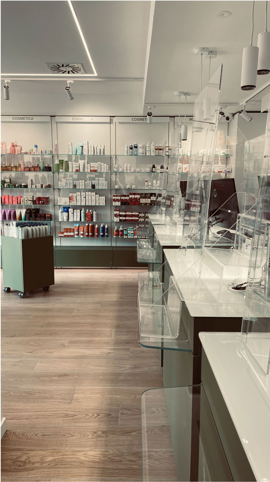 Pharmacy interior with wall displays, green furniture and wood-effect flooring