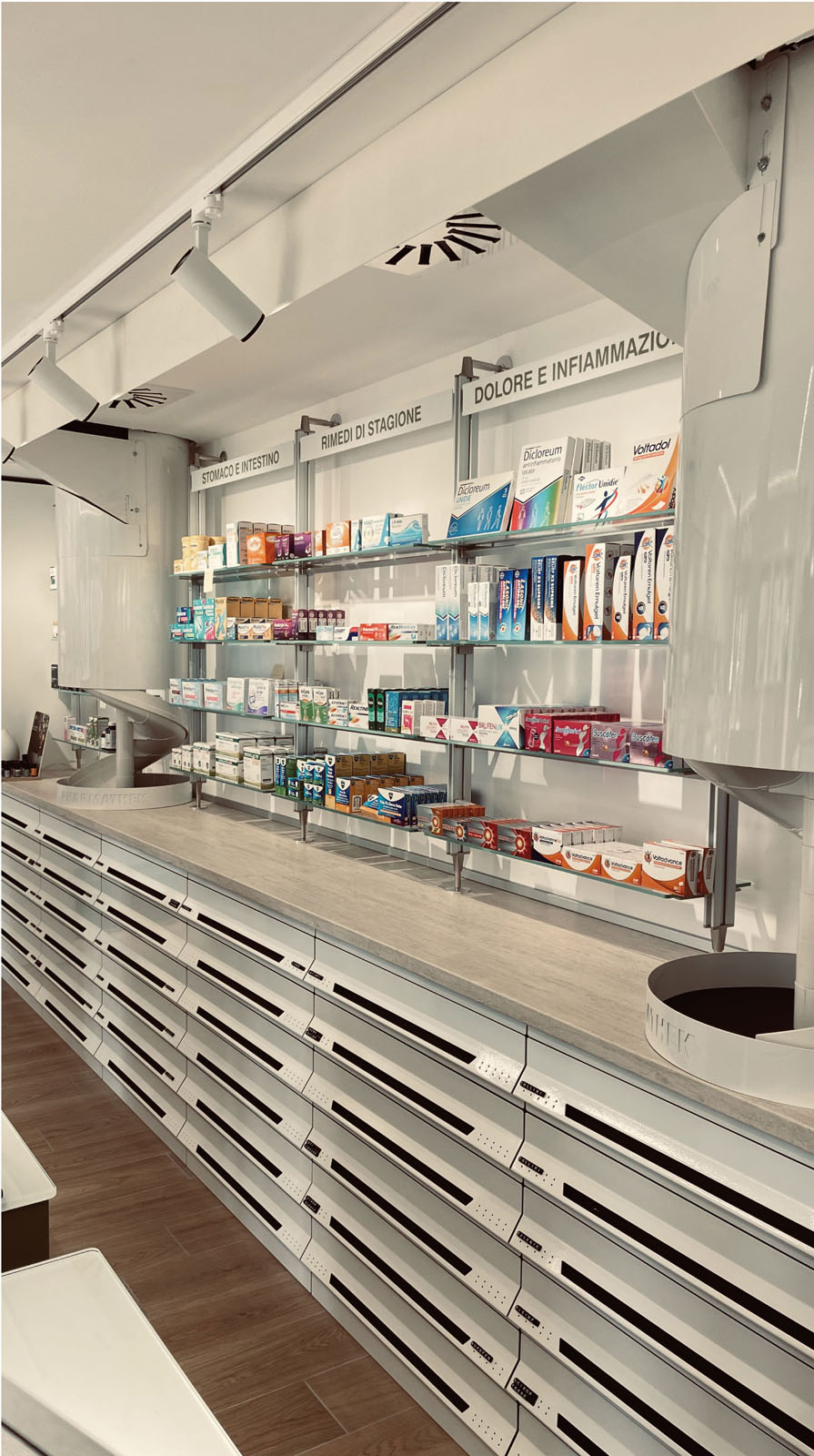 Pharmacy service counter with drawer units, equipped wall and seasonal product display