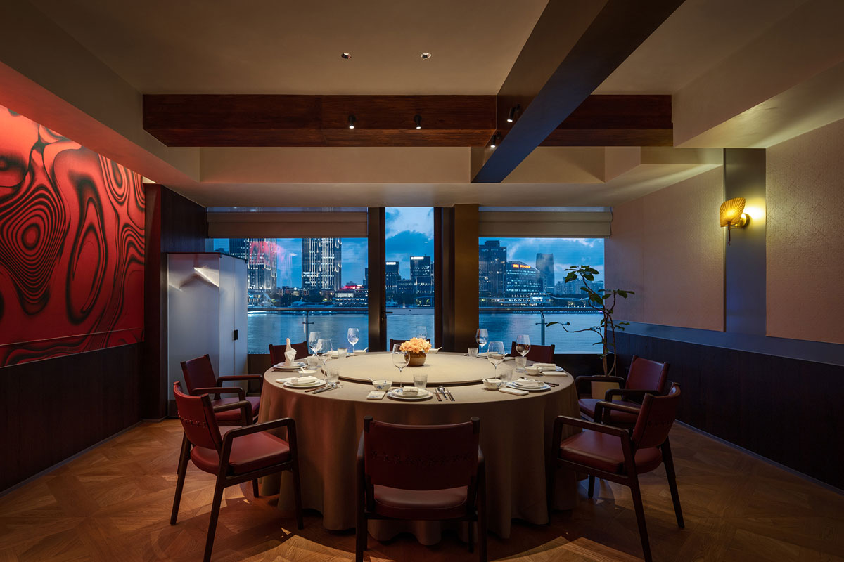 Dining table overlooking the Huangpu River through floor-to-ceiling glazing
