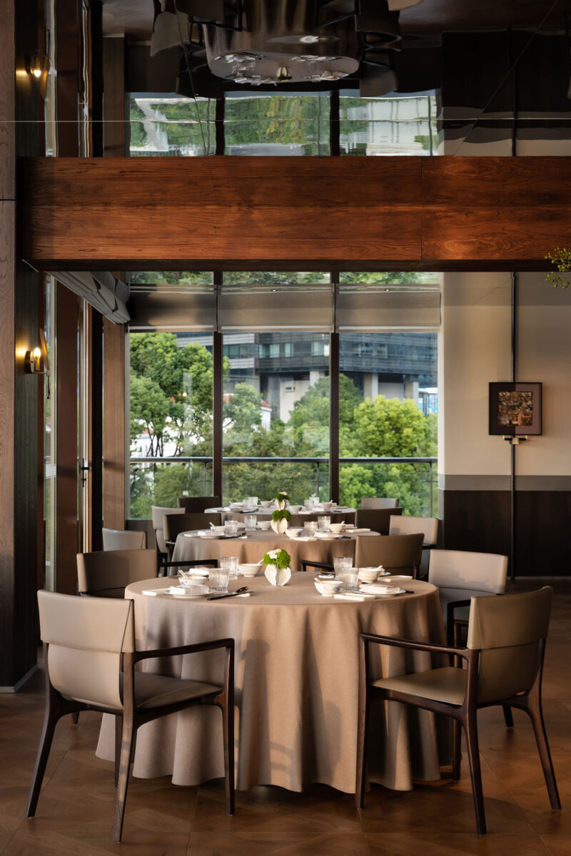 Main dining room at Shu Pavilion Restaurant with mirrored ceiling, round tables and panoramic waterfront views