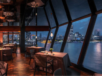Interni del Shu Pavilion Restaurant a Shanghai con sala da pranzo, grandi vetrate panoramiche e vista sul fiume Huangpu di notte