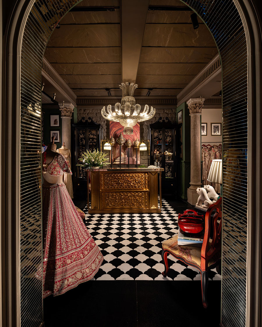 Entrance to GG Fort by Gazal Gupta with carved counter, monumental chandelier and arched retail pathway in New Delhi.