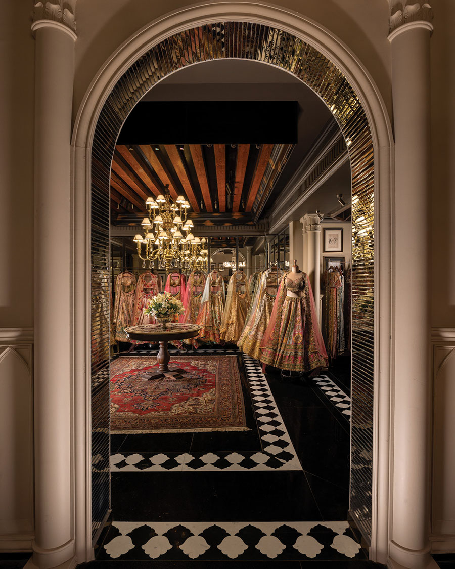 GG Fort interior with stone columns, bespoke counter and decorative chandeliers enhancing the retail path.