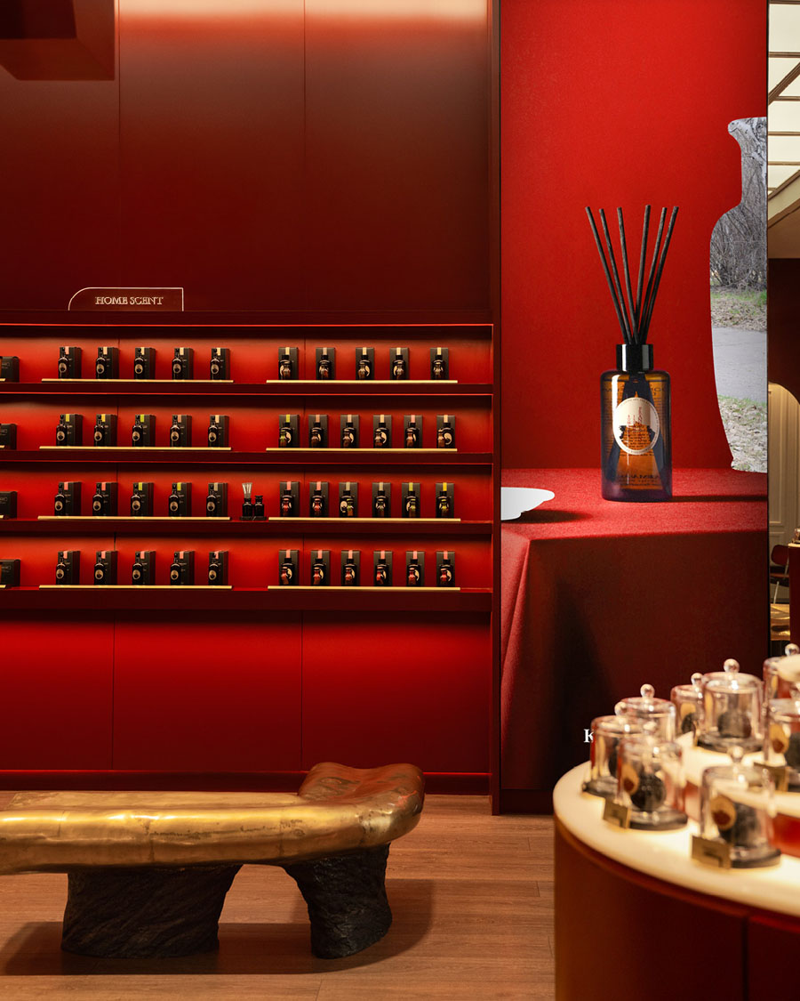 Fragrance display area at Karmakamet with red walls and illuminated shelving