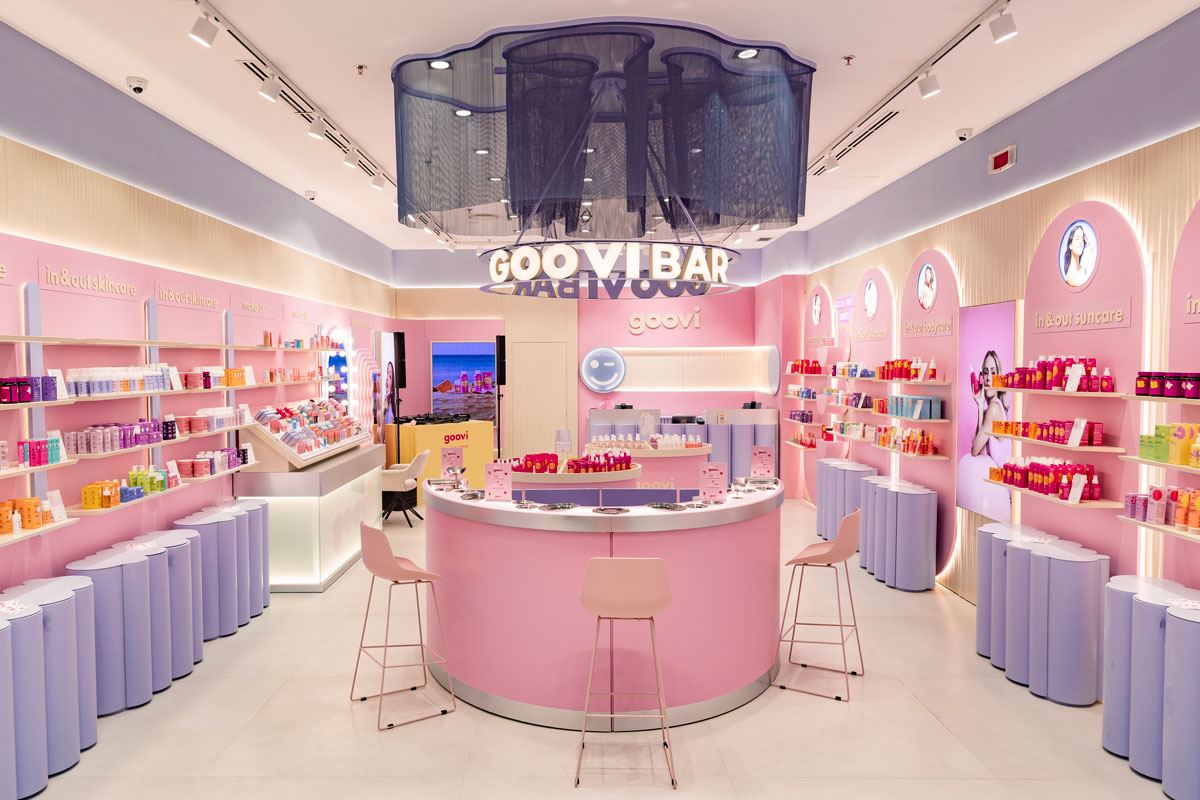 Interior of Goovi's first flagship store in Grugliasco featuring the central Goovi Bar, curved furnishings, a pink colour palette and a retail journey dedicated to in & out wellbeing.