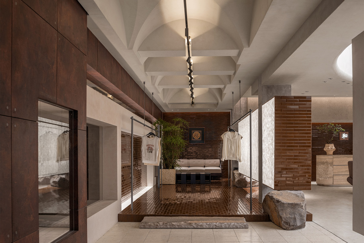 Display route in the Hé showroom with vaulted ceilings, track lighting, display systems and lounge area