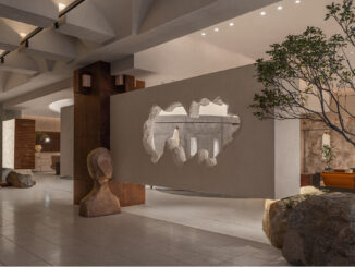 Ingresso dello showroom Hé progettato da LubanEra•Design con apertura scultorea nel volume sospeso, pietra naturale e percorso espositivo
