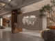 Ingresso dello showroom Hé progettato da LubanEra•Design con apertura scultorea nel volume sospeso, pietra naturale e percorso espositivo