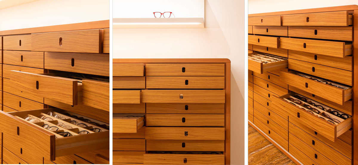 Cassettiera espositiva in legno recuperata con cassetti porta montature restaurati durante il restyling di Ottica Adami.