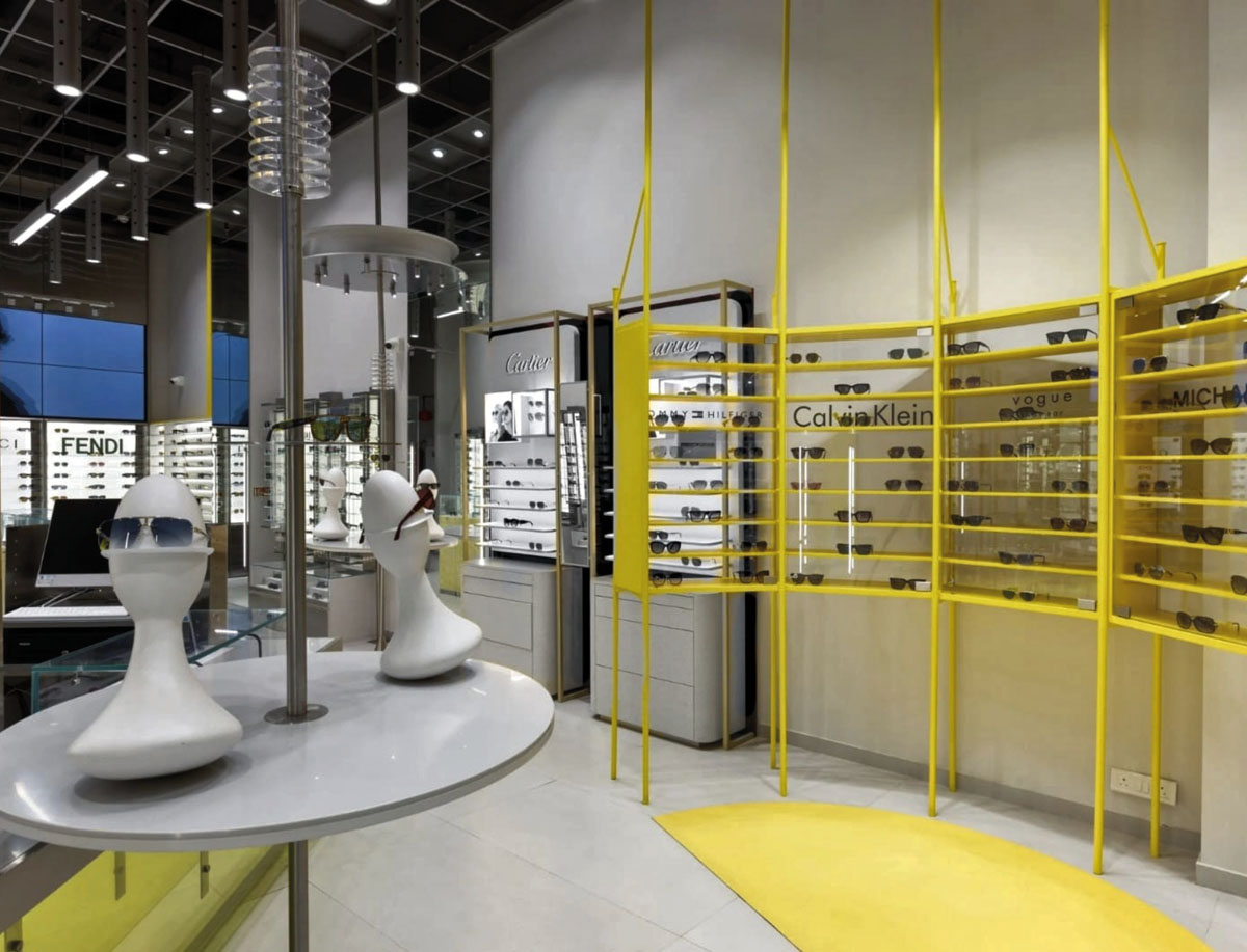 Yellow display structure and mannequin heads inside the OPIQ optical store