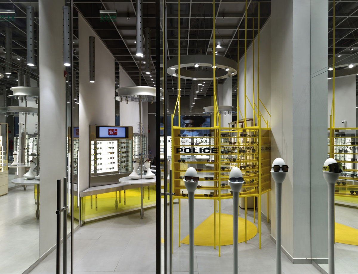 Entrance to the OPIQ optical store with yellow display structure and eyewear