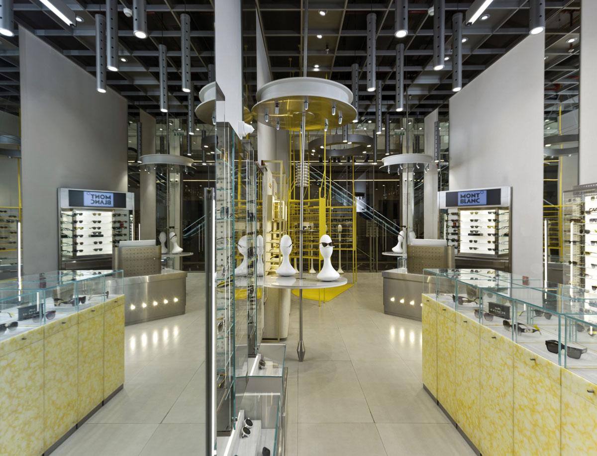 OPIQ interior with glass showcases, yellow displays and circular ceiling installations