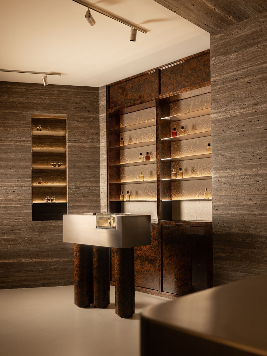 Vertical fragrance displays with travertine, metal and burl wood at Jolie