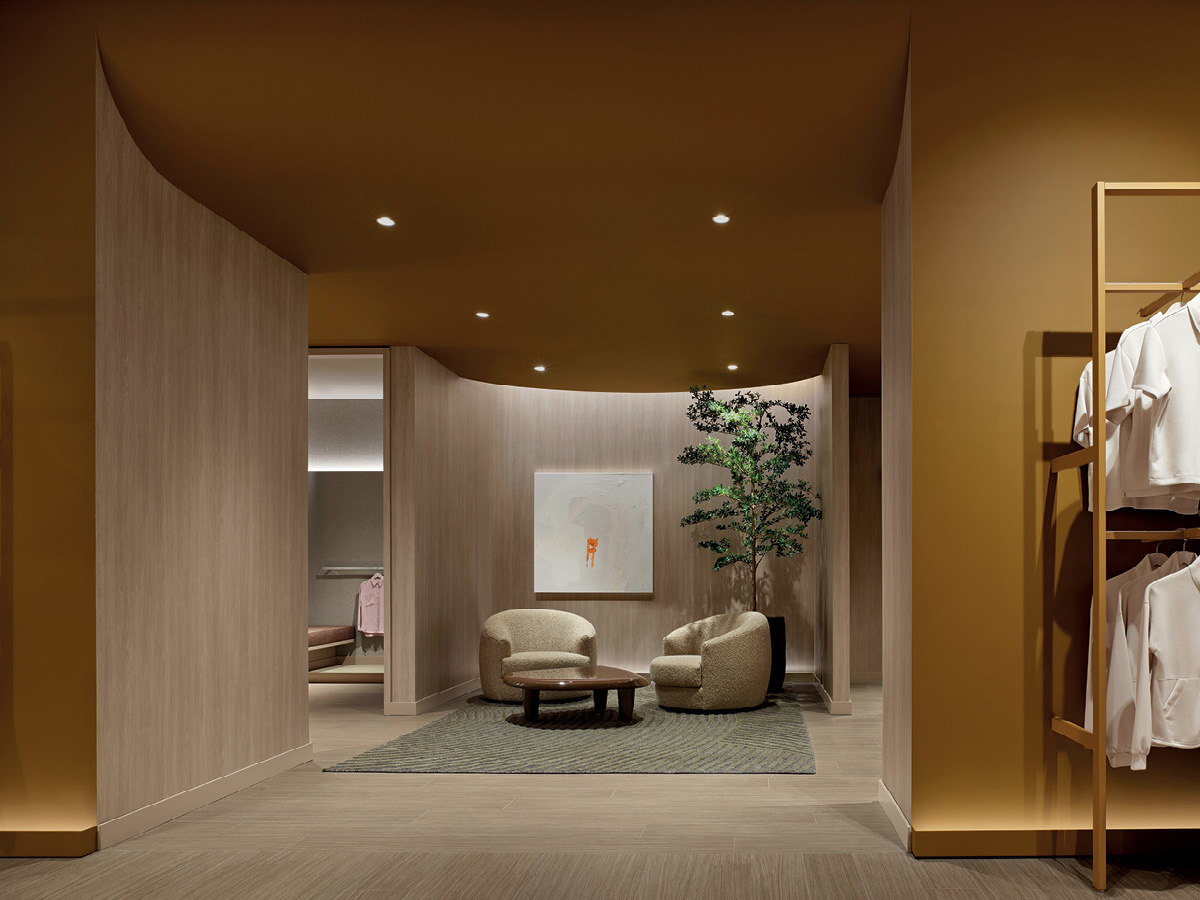 Reitmans lounge with armchairs, coffee table, rug and light wood walls