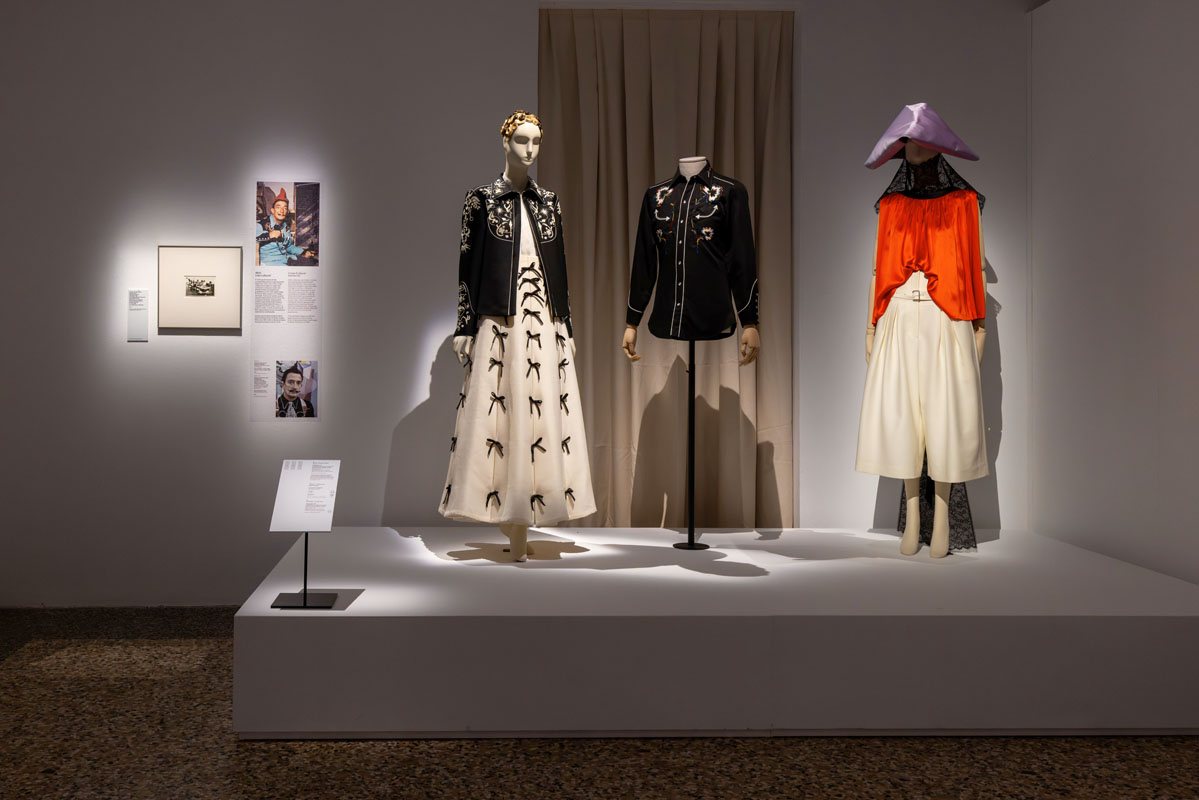 Garments displayed on a platform against a dark backdrop at Dalí and Fashion