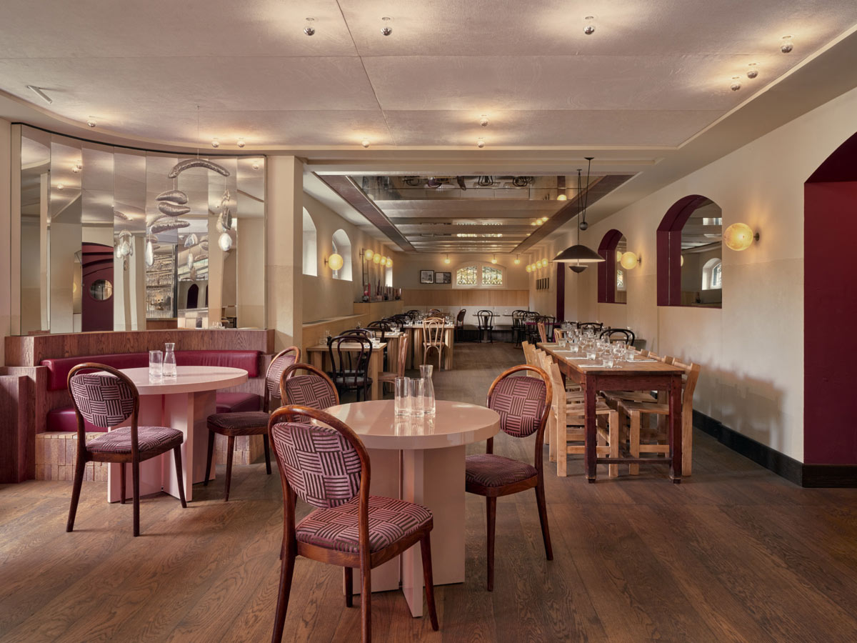 Sala principale di Café Vertigo con tavoli in legno e grandi specchi