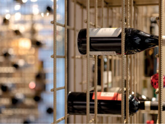 Bottiglie di vino nel sistema espositivo di Enoteca da Aldo a Bolzano