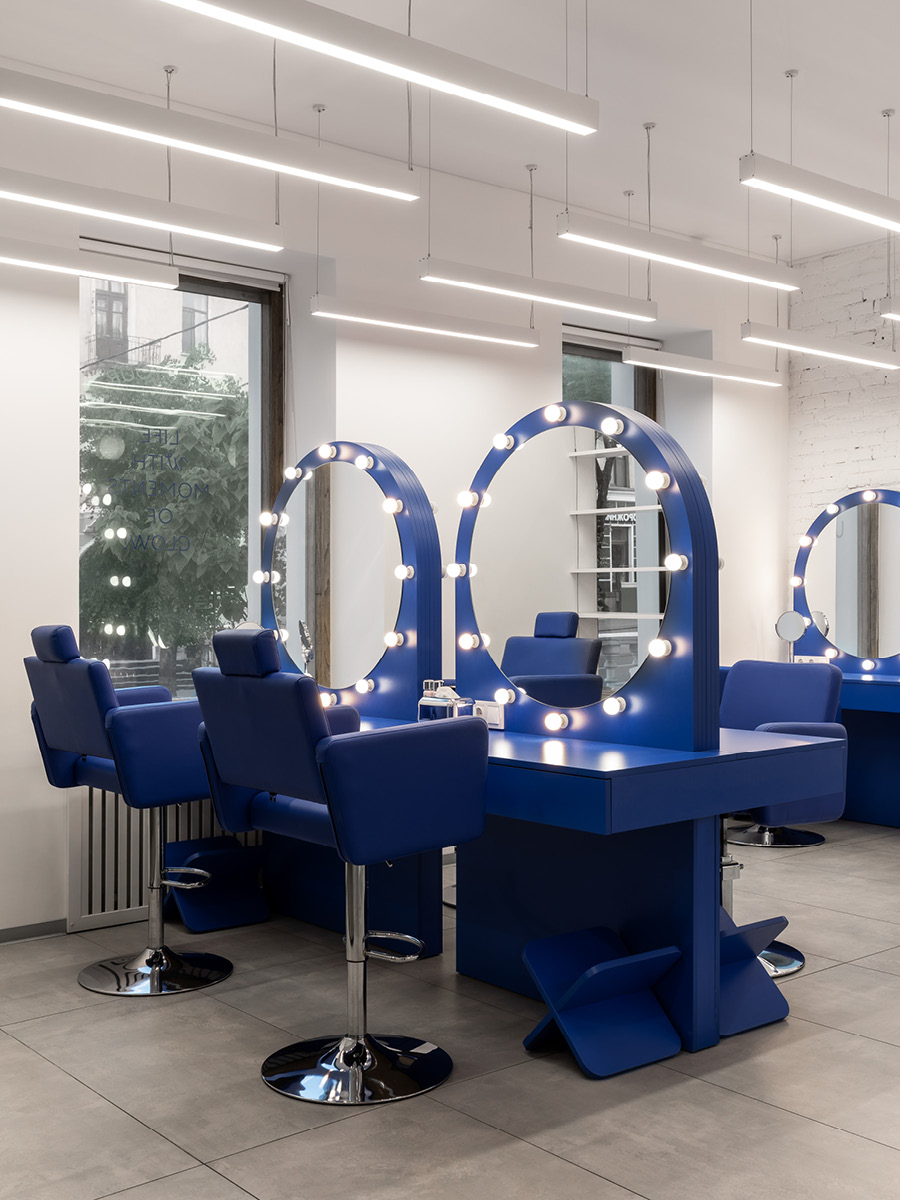 Hair styling area at G×BAR in Ternopil with blue furniture and illuminated mirrors