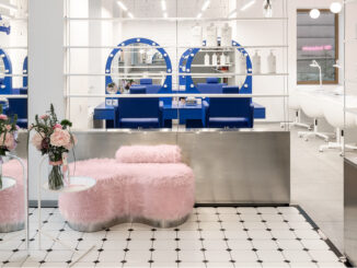 Interno del beauty store G×BAR a Ternopil con arredi blu, seduta rosa e superfici specchianti