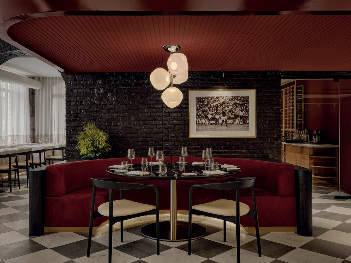 Dining area at Mare restaurant in Montréal with red banquette and chequerboard floor