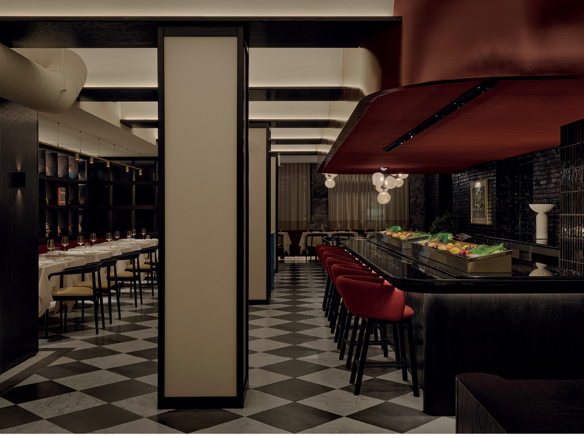 Central counter at Mare restaurant in Montréal beneath a suspended red timber volume