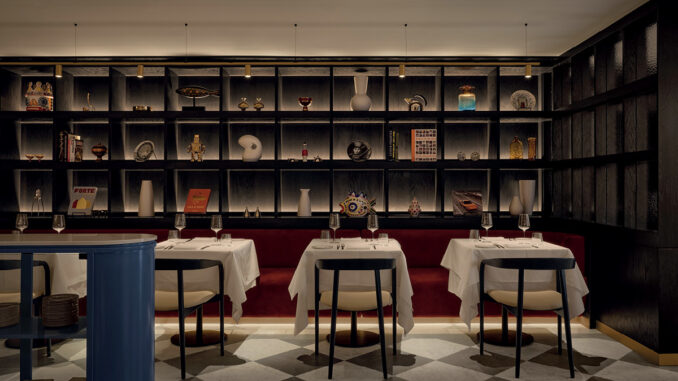 Sala del ristorante Mare a Montréal con banquette rossa e parete espositiva illuminata