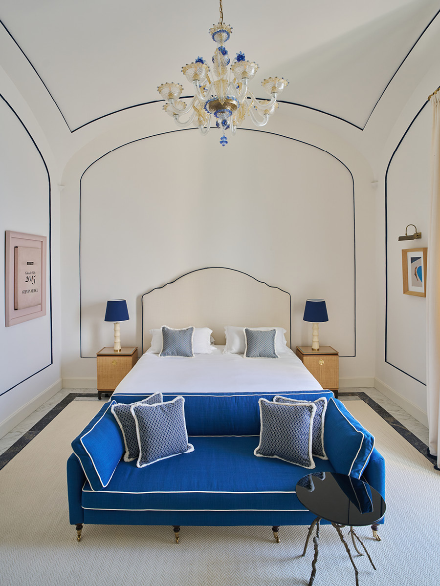 Camera per gli ospiti dell'Hotel du Tasso con arredi su misura, dettagli blu e volta architettonica