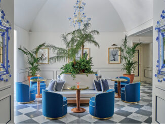 Hall dell’Hotel du Tasso a Sorrento progettata da Antonio Girardi, con sedute blu, specchi veneziani e vegetazione centrale.