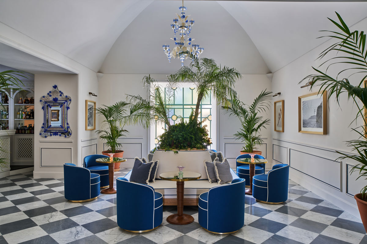 Hall dell'Hotel du Tasso a Sorrento con sedute blu, volta storica e composizione vegetale centrale
