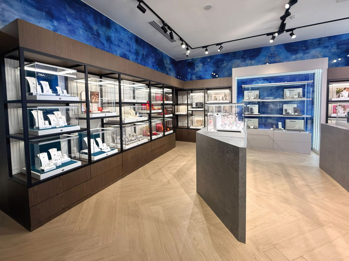 Boutique Intuera Jewellery a Baku con vetrine perimetrali, espositore centrale e pavimento a spina di pesce