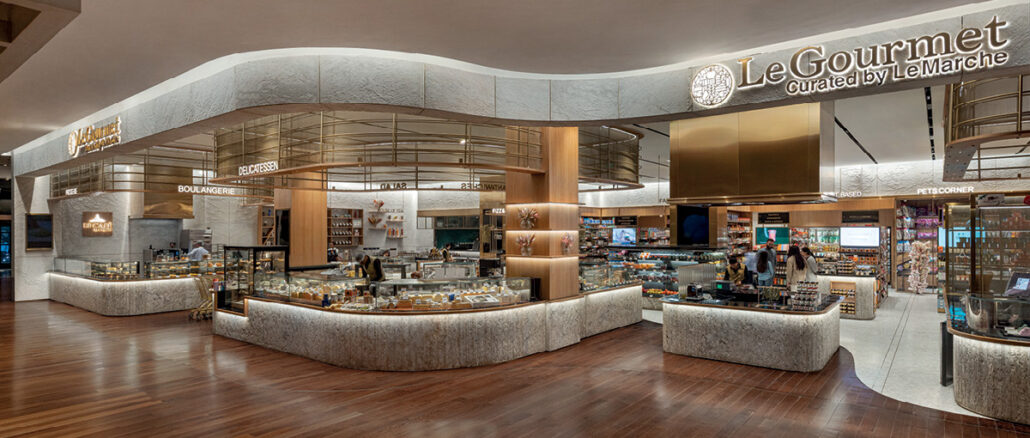 Vista panoramica di Le Gourmet al The Chanakya Mall di New Delhi, con banchi curvi e aree espositive alimentari.