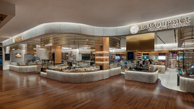 Vista panoramica di Le Gourmet al The Chanakya Mall di New Delhi, con banchi curvi e aree espositive alimentari.