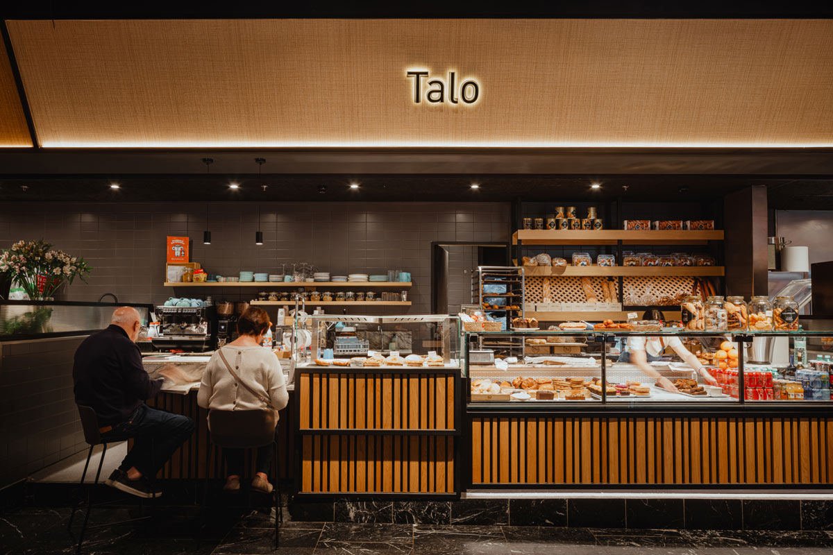 Banco Talo al Mercato San Martin, con rivestimento in listelli di legno, vetrine espositive e illuminazione integrata