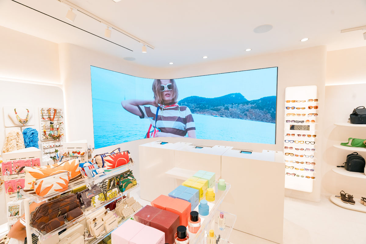 Area accessori del flagship Parfois a Milano con grande schermo digitale angolare e arredi espositivi bianchi