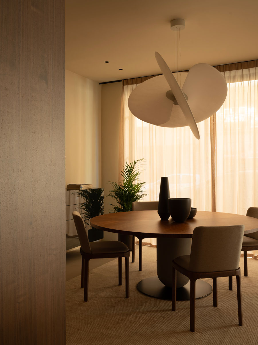 Zona pranzo dello showroom Pianca a Palermo con tavolo rotondo e lampada a sospensione scultorea