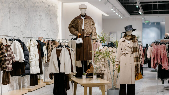 Negozio di abbigliamento con espositori e manichini, immagine illustrativa dello shopping natalizio e dei saldi invernali