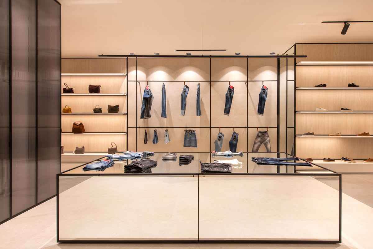 Showroom D’Asdia a Palermo, area espositiva dedicata al denim con strutture metalliche e banco centrale